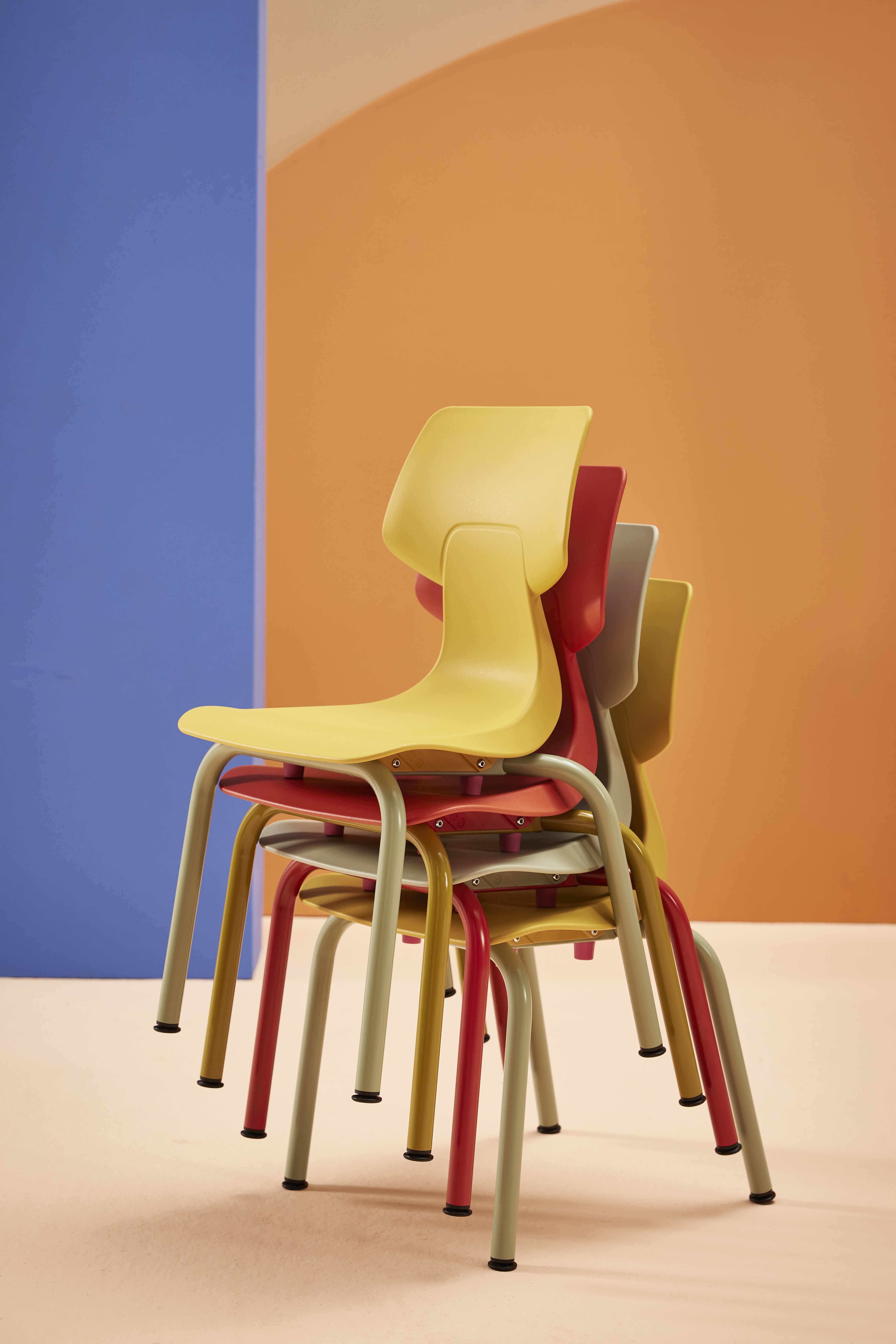 Gispen WIZZ 4 leg frame in red and yellow chairs stacked in a blue pink primary education setting front right view